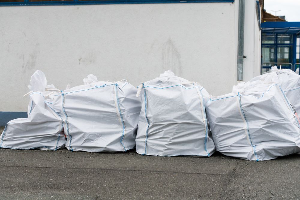 A pile of white bags sitting in front of a building — Pigot's Mid Western Sand and Soil In Orange, NSW