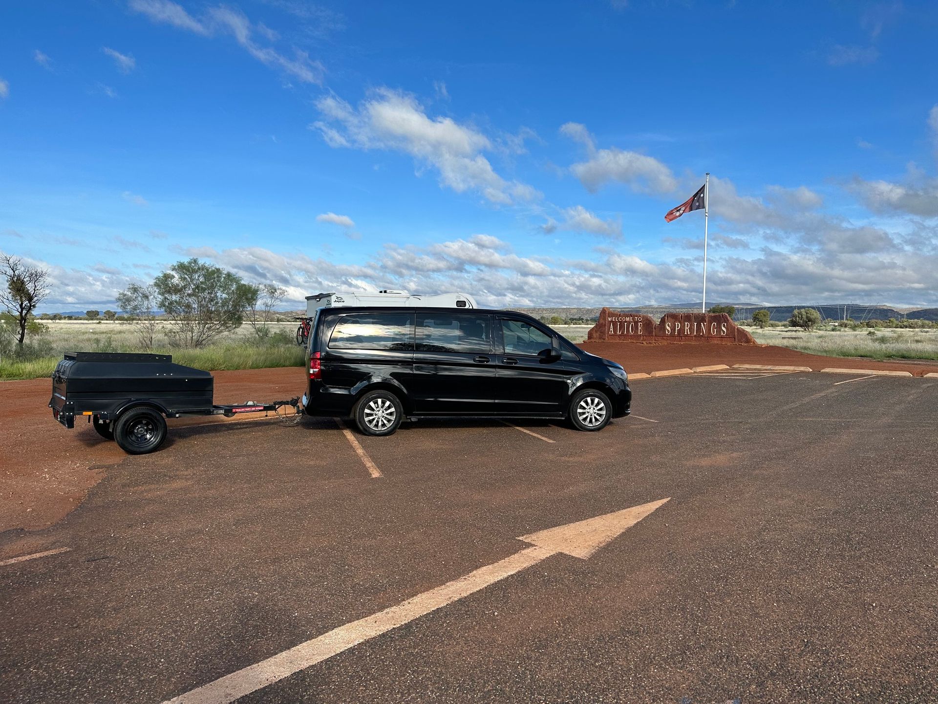 Black SUV Towing a Small Trailer on a Dirt Road — ASP Private Hire in Ross, NT
