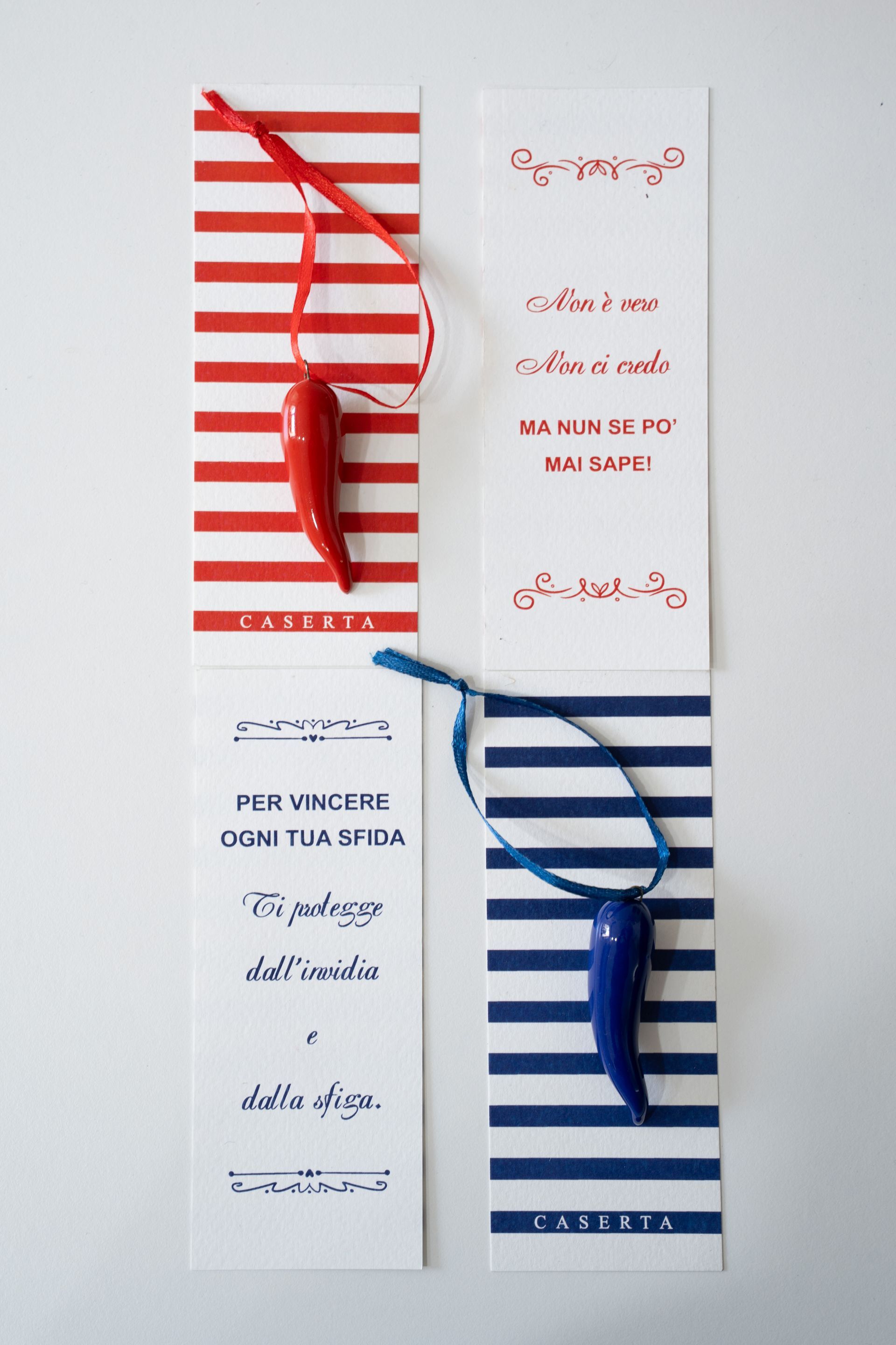 Due brochure a righe con occhiali da sole rossi e blu su sfondo chiaro