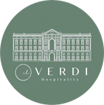 Logo VERDI Hospitality con illustrazione di un edificio bianco su sfondo circolare verde salvia.