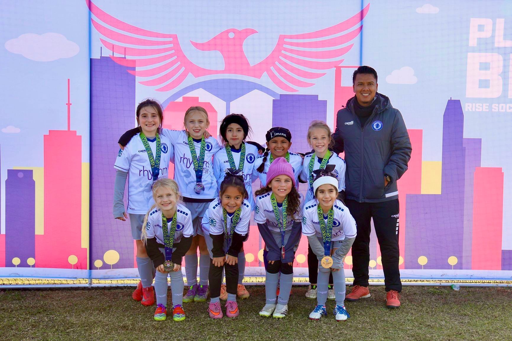 Albion Hurricanes FC team posing with medals and coach