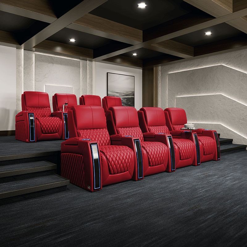 Red reclining theater seats in a dark home cinema room with steps and recessed ceiling lights