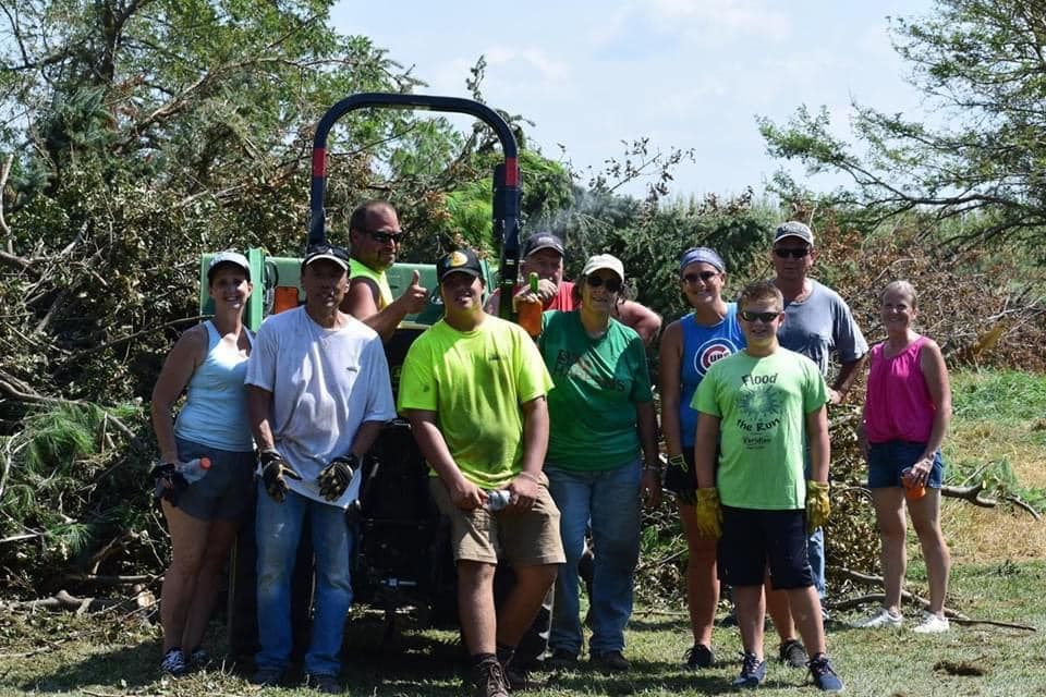 A group of people are posing for a picture in front of a tractor.