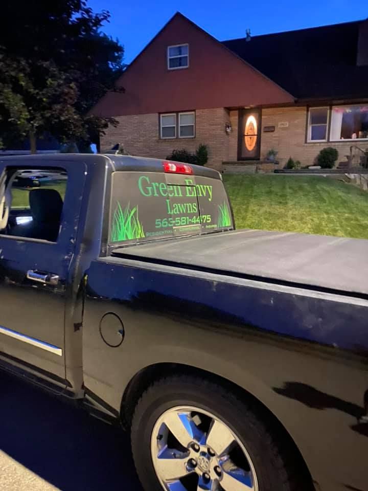 A black truck is parked in front of a house.