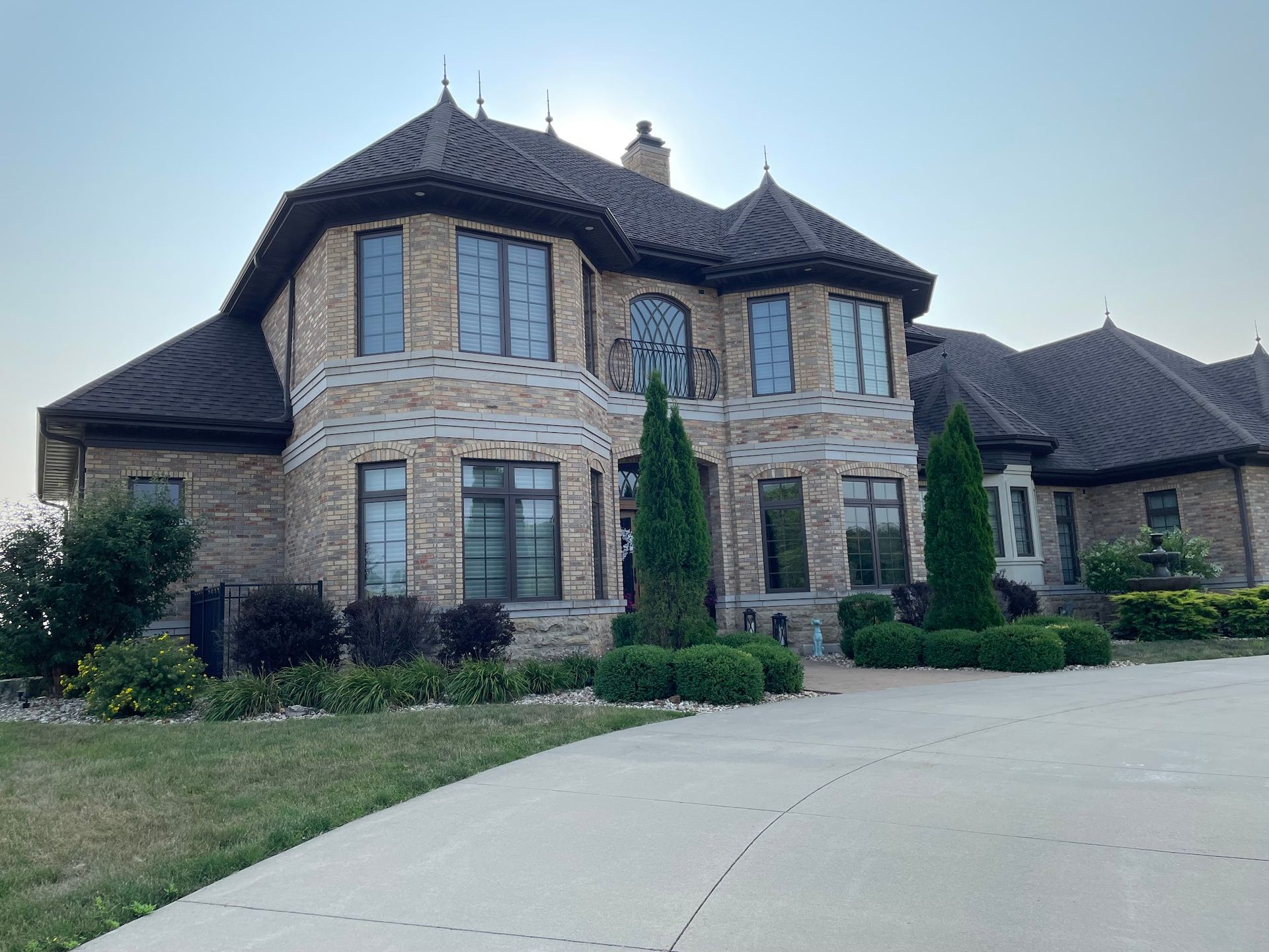 A large brick house with a lot of windows and trees in front of it.