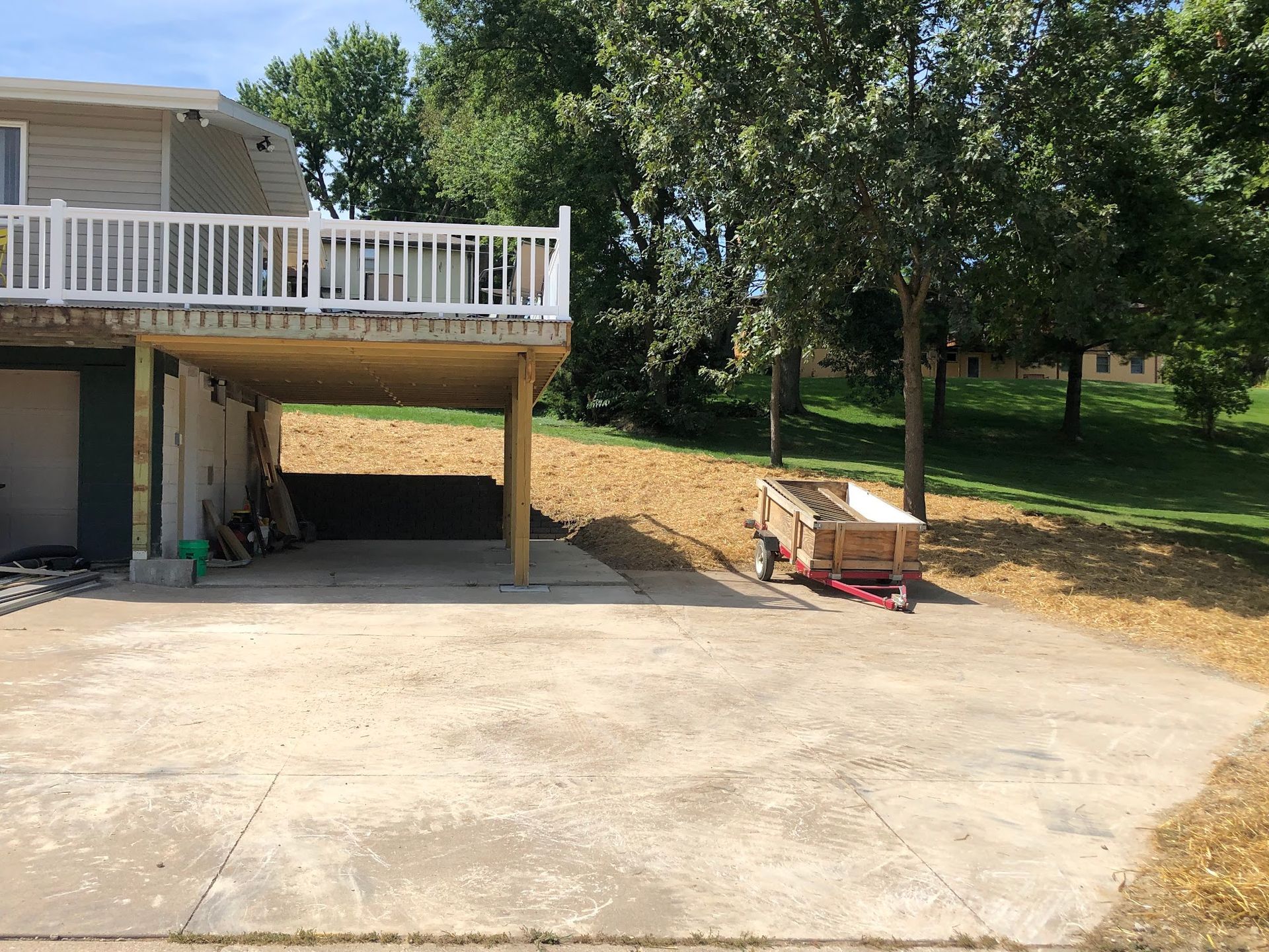 A house with a deck and a carport underneath it.