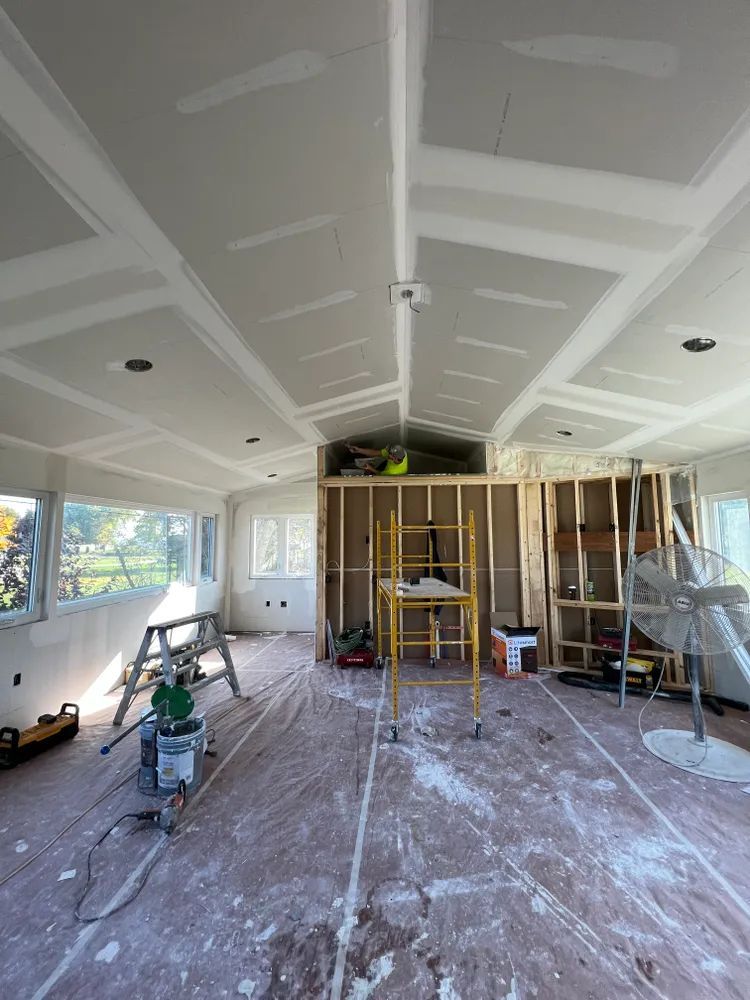 A large room with a scaffolding in the middle of it is being remodeled.