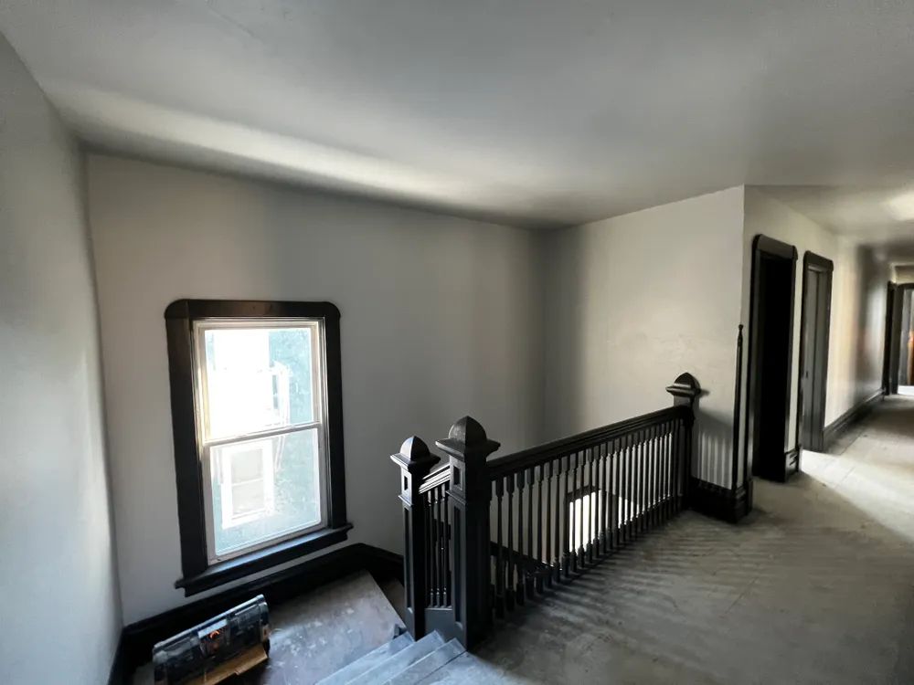 An empty hallway with stairs and a window