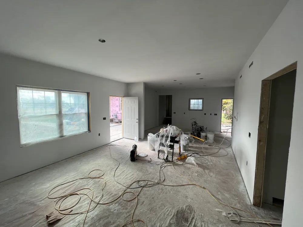 A large room with a lot of windows and a lot of wires on the floor.