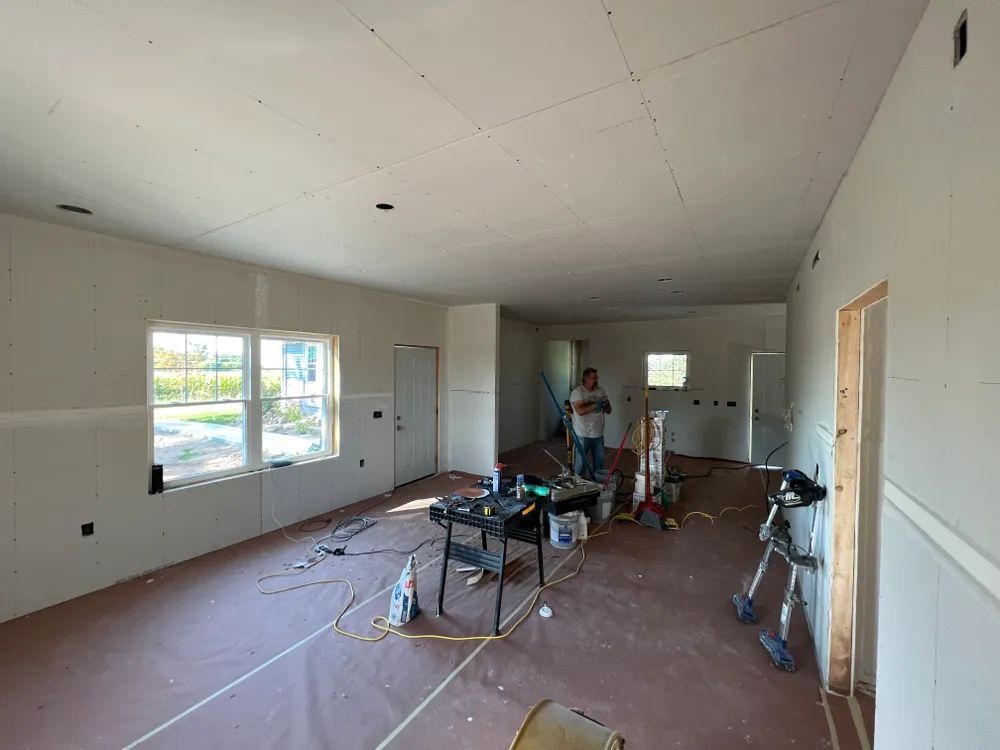 A man is standing in a room that is being remodeled.