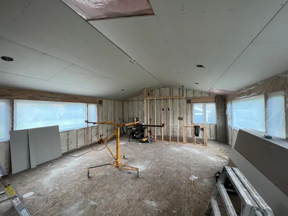 A room with a lot of windows and a ladder in it.