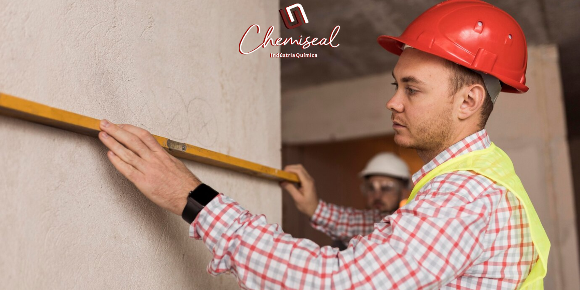 Trabalhador da construção civil usando capacete vermelho e colete de segurança