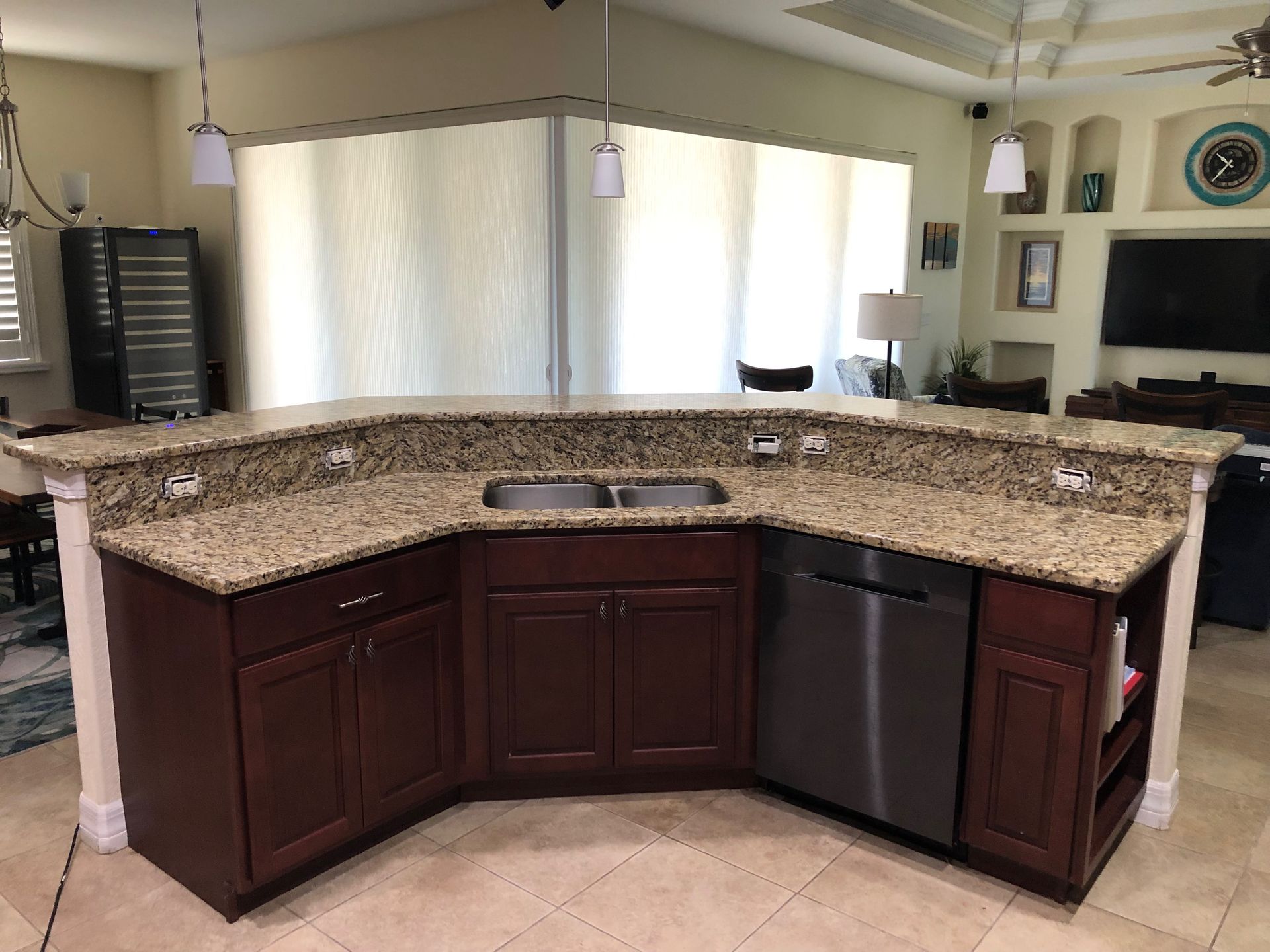 Kitchen island with dark wood cabinets and granite countertop in a bright open living room