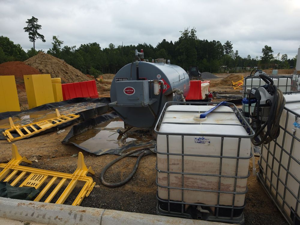 SMR Rapid Response crew in PPE containing an industrial oil spill with spill-recovery totes and containment