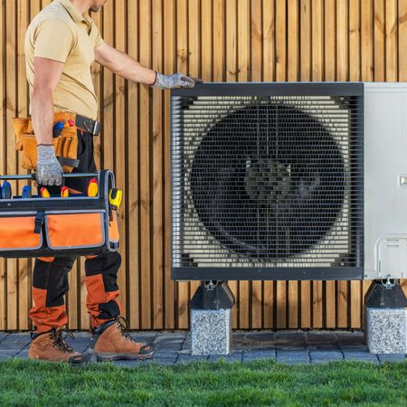Dunn Right HVAC LLC | a man is standing next to a fan and holding a toolbox.