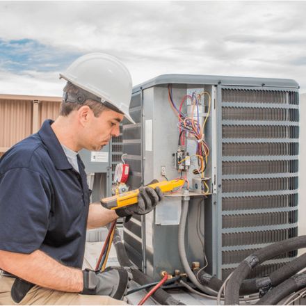 Dunn Right HVAC LLC | a man wearing a hard hat is working on an air conditioner.