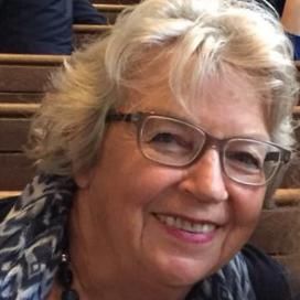 Pianodocent Erna Menke uit Badhoevedorp met bril in een houten binnenomgeving.