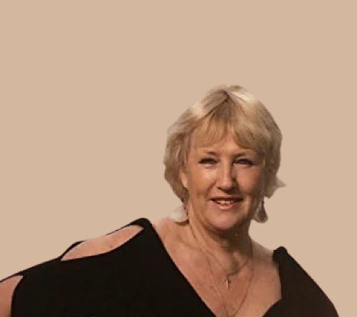 Pianodocent Sylvia van Santen uit Noord Holland  in een zwarte top tegen een effen beige achtergrond.