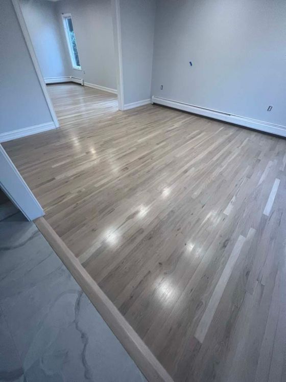 A living room with hardwood floors and a window.