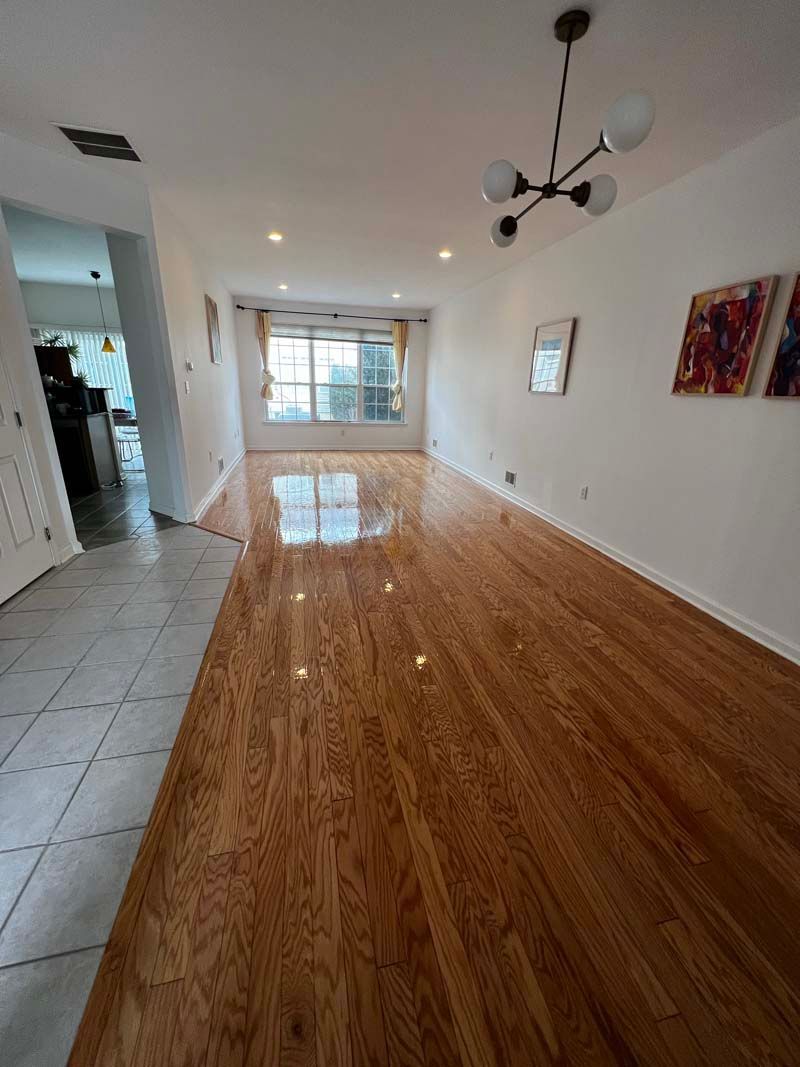 A living room with hardwood floors and white walls.