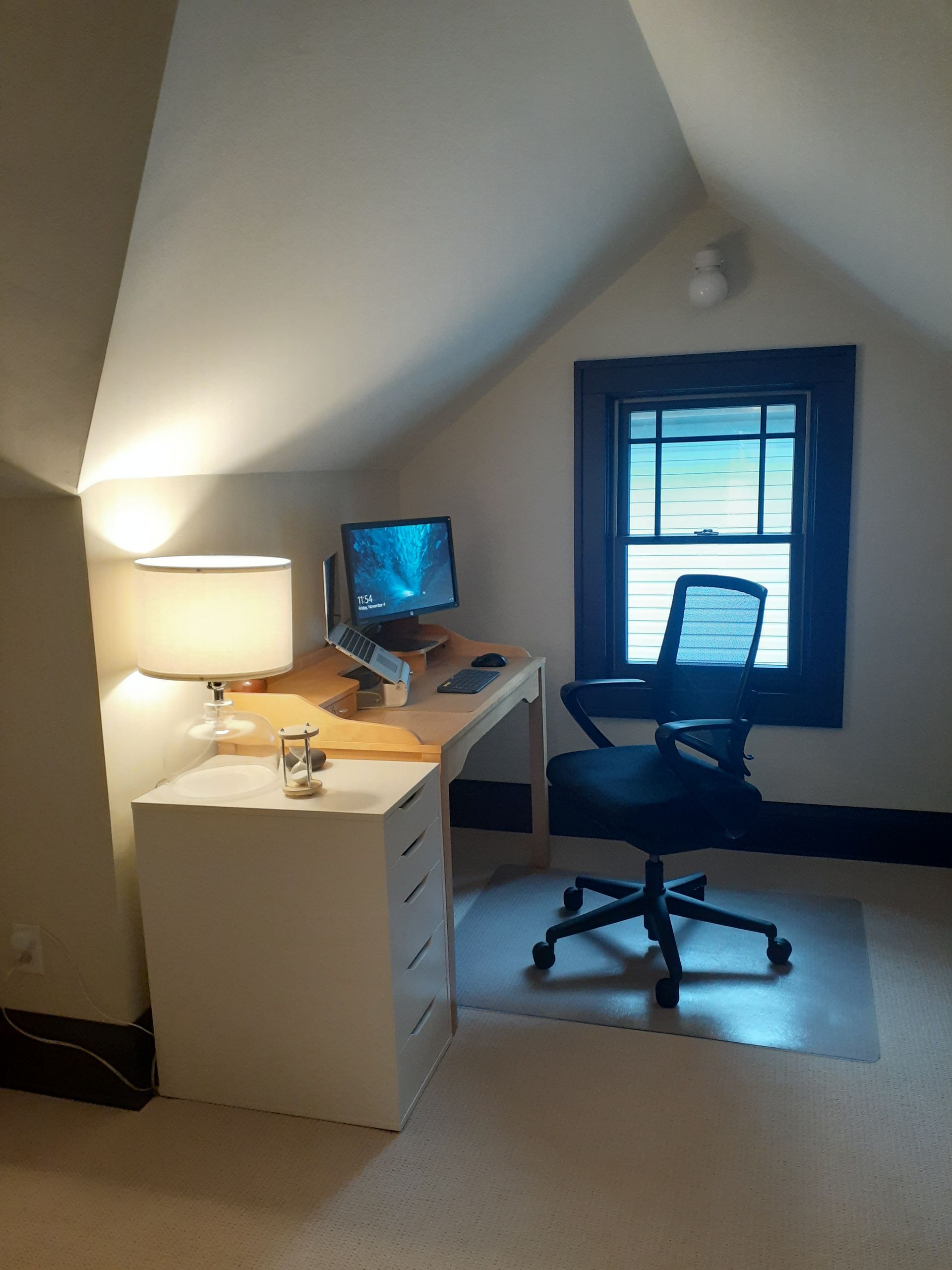A room with a desk and chair and a computer on it