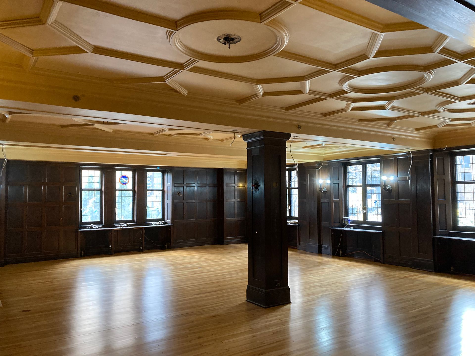 A large empty room with a wooden floor and a ceiling