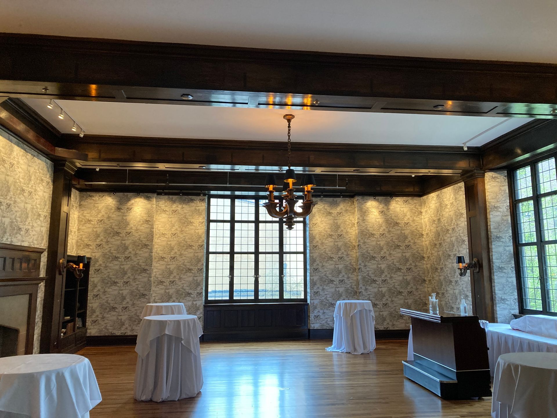A large room with tables and a chandelier hanging from the ceiling