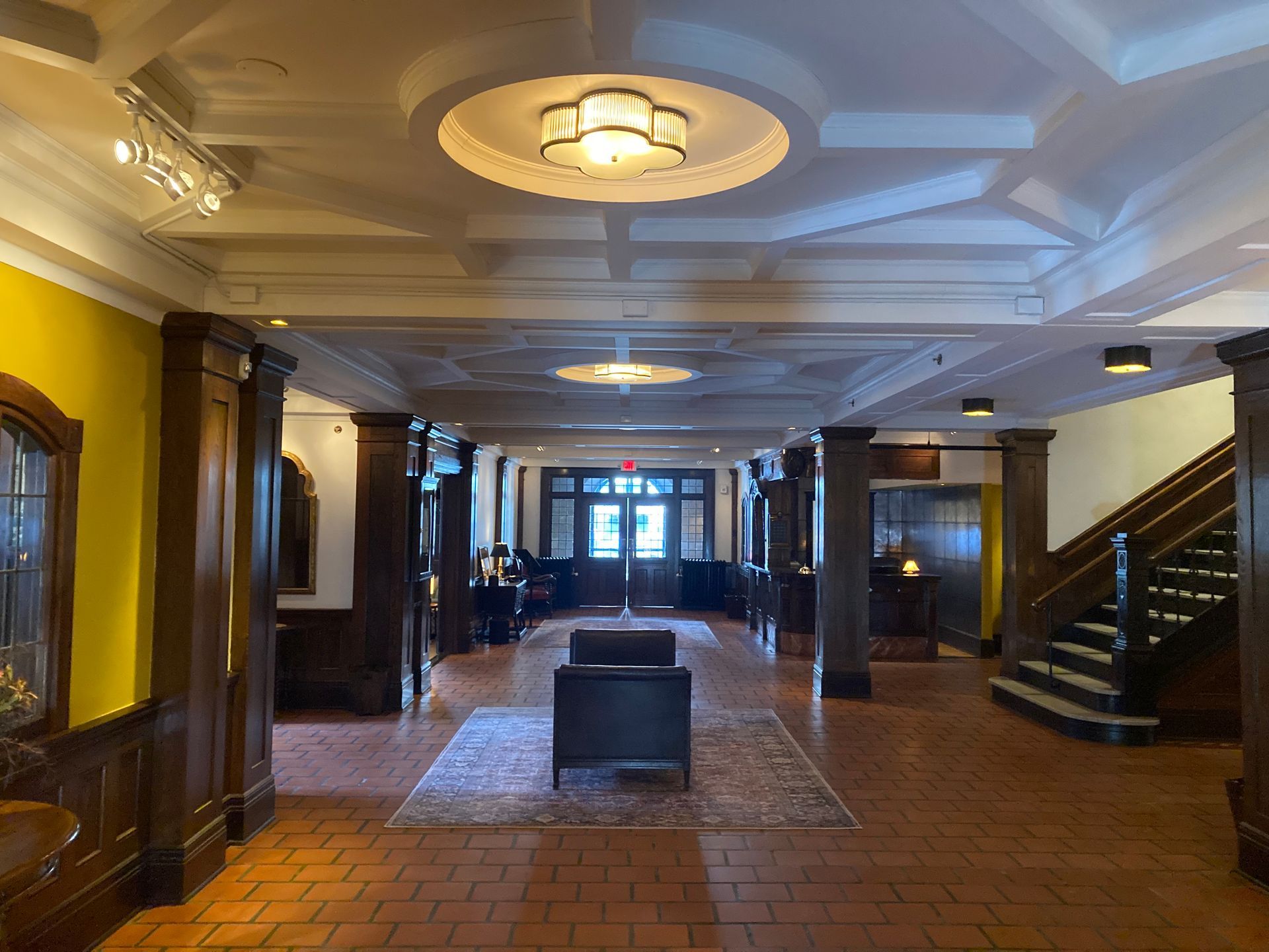 A large hallway with stairs and a chair in the middle
