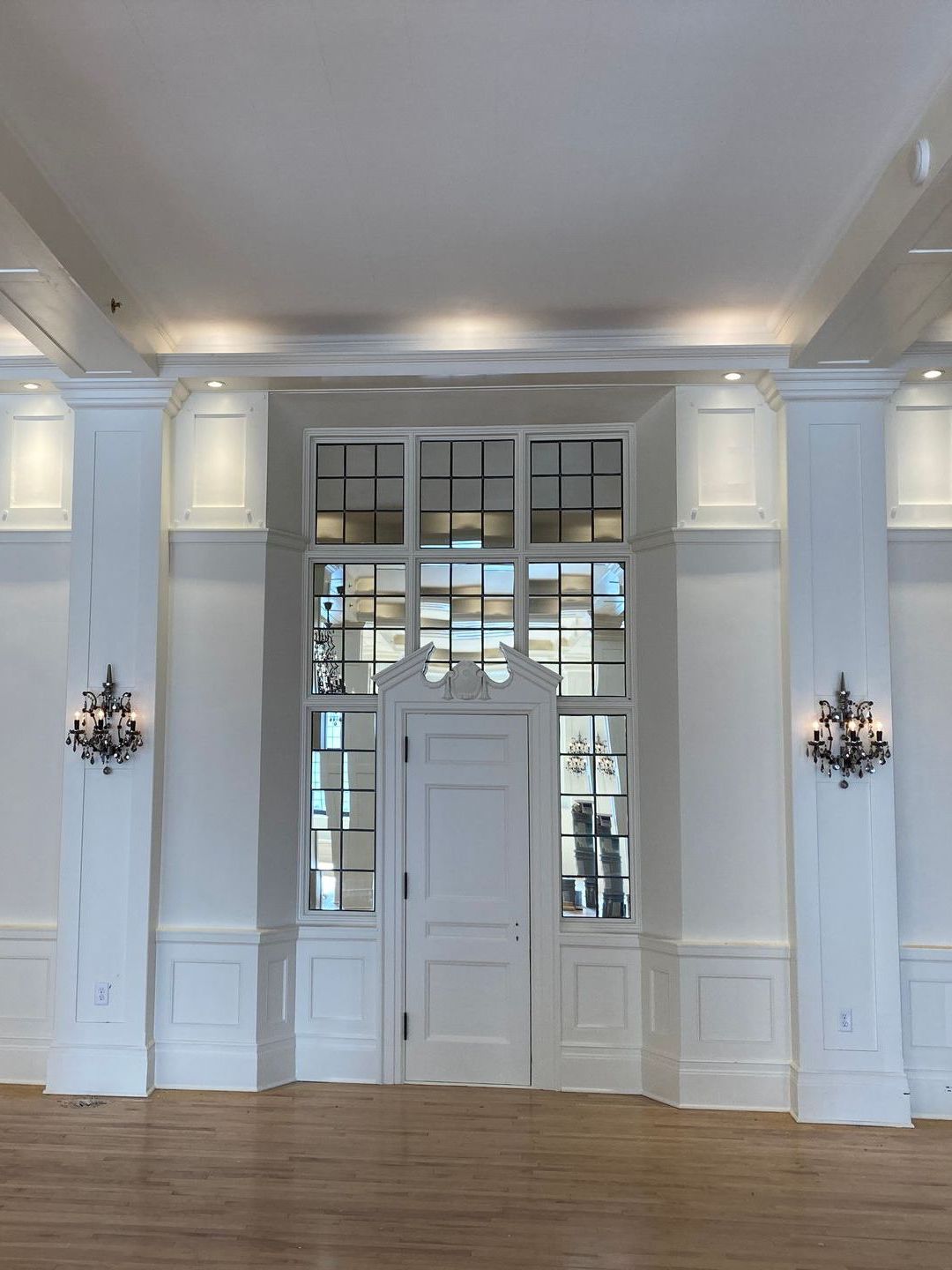 A large empty room with white walls and wooden floors