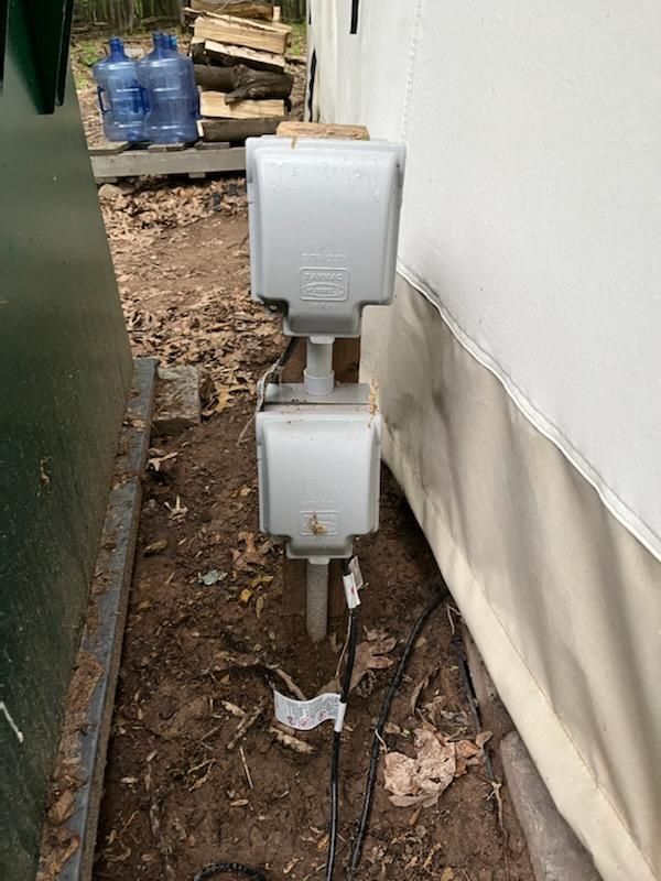 There are two electrical outlets on the side of a building.