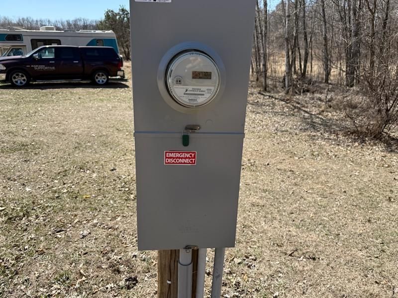 A gray box with a meter on it in a field