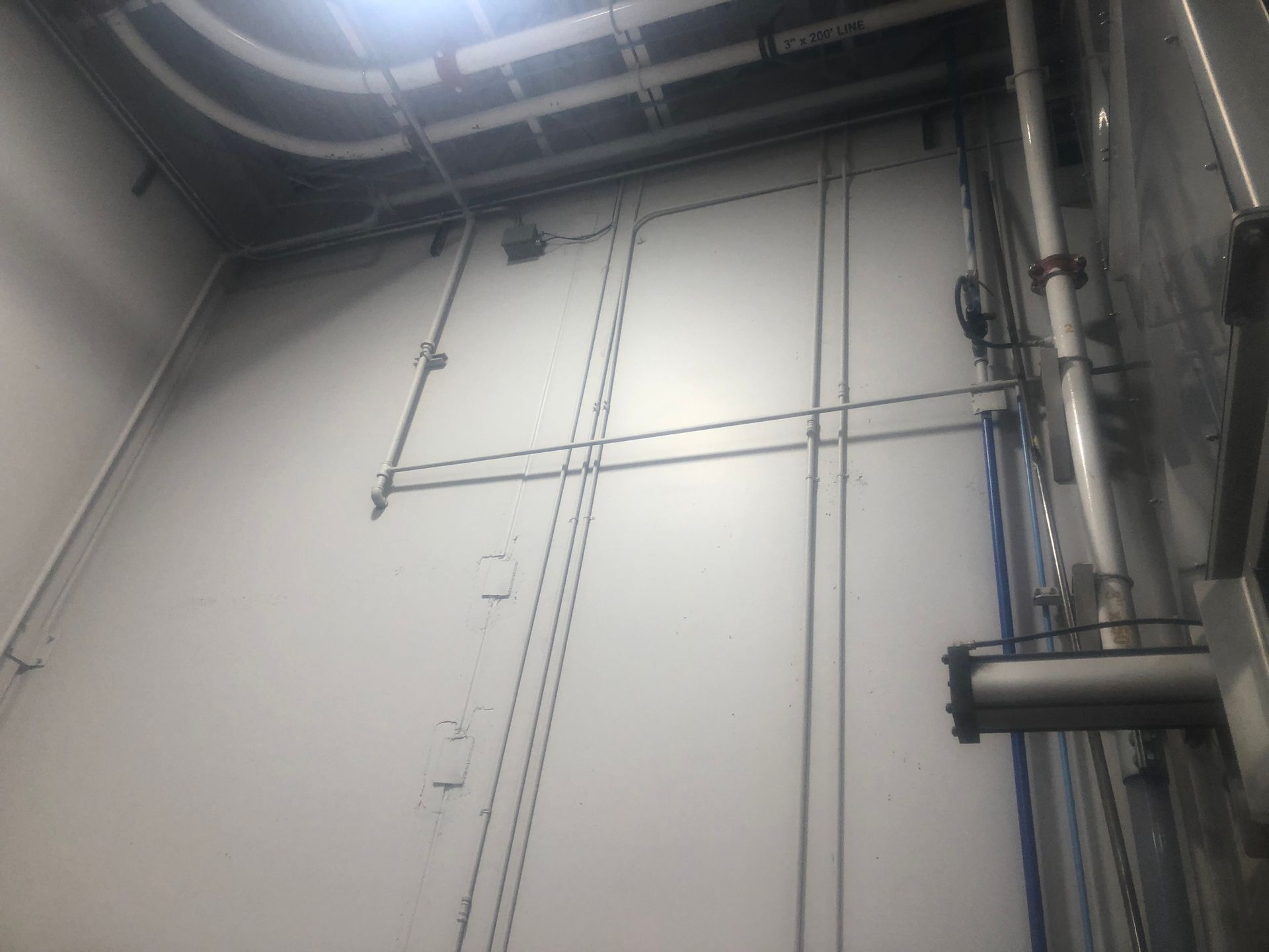 A room with a lot of pipes hanging from the ceiling.