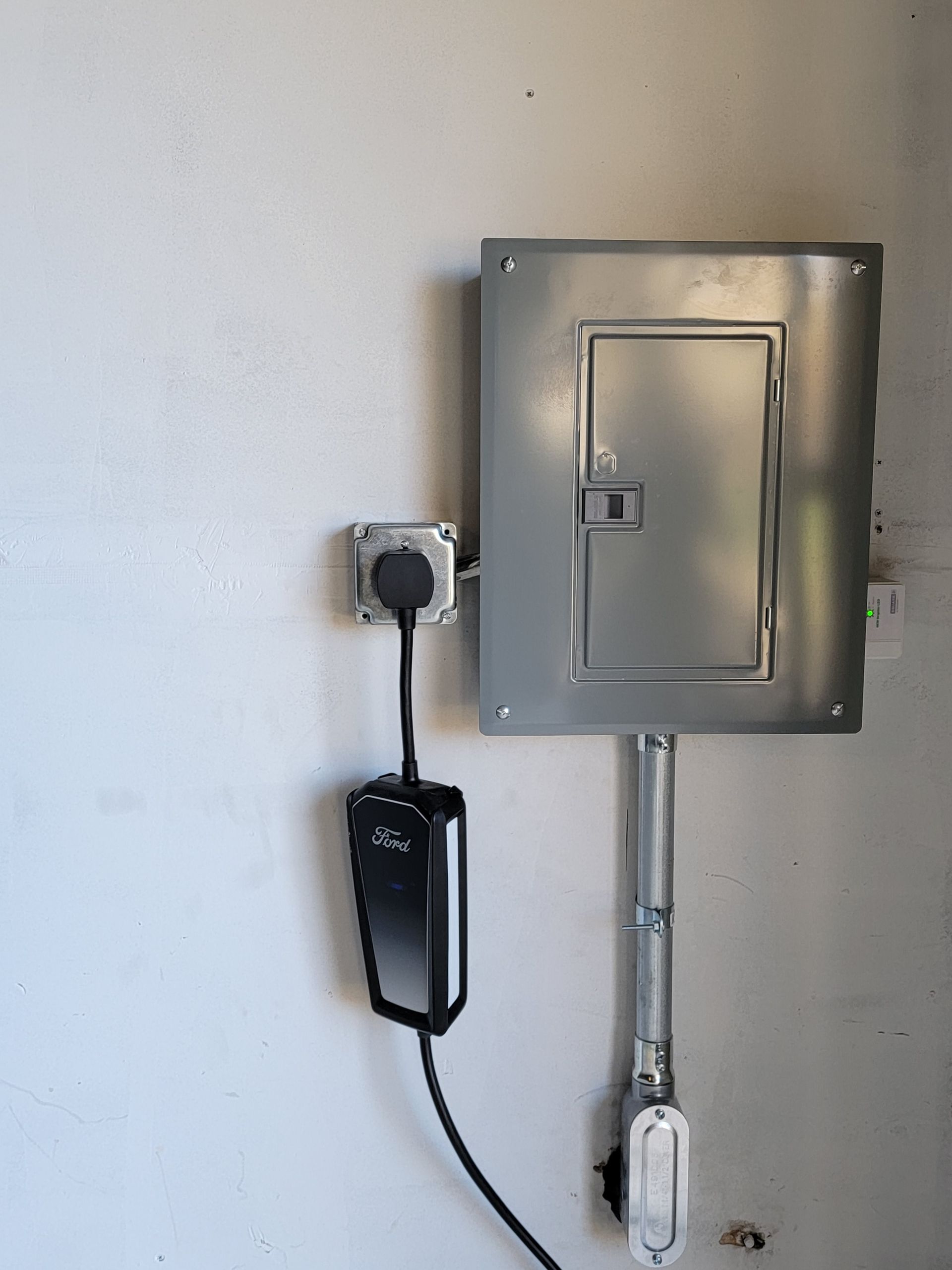 A charger is plugged into a electrical box on a wall
