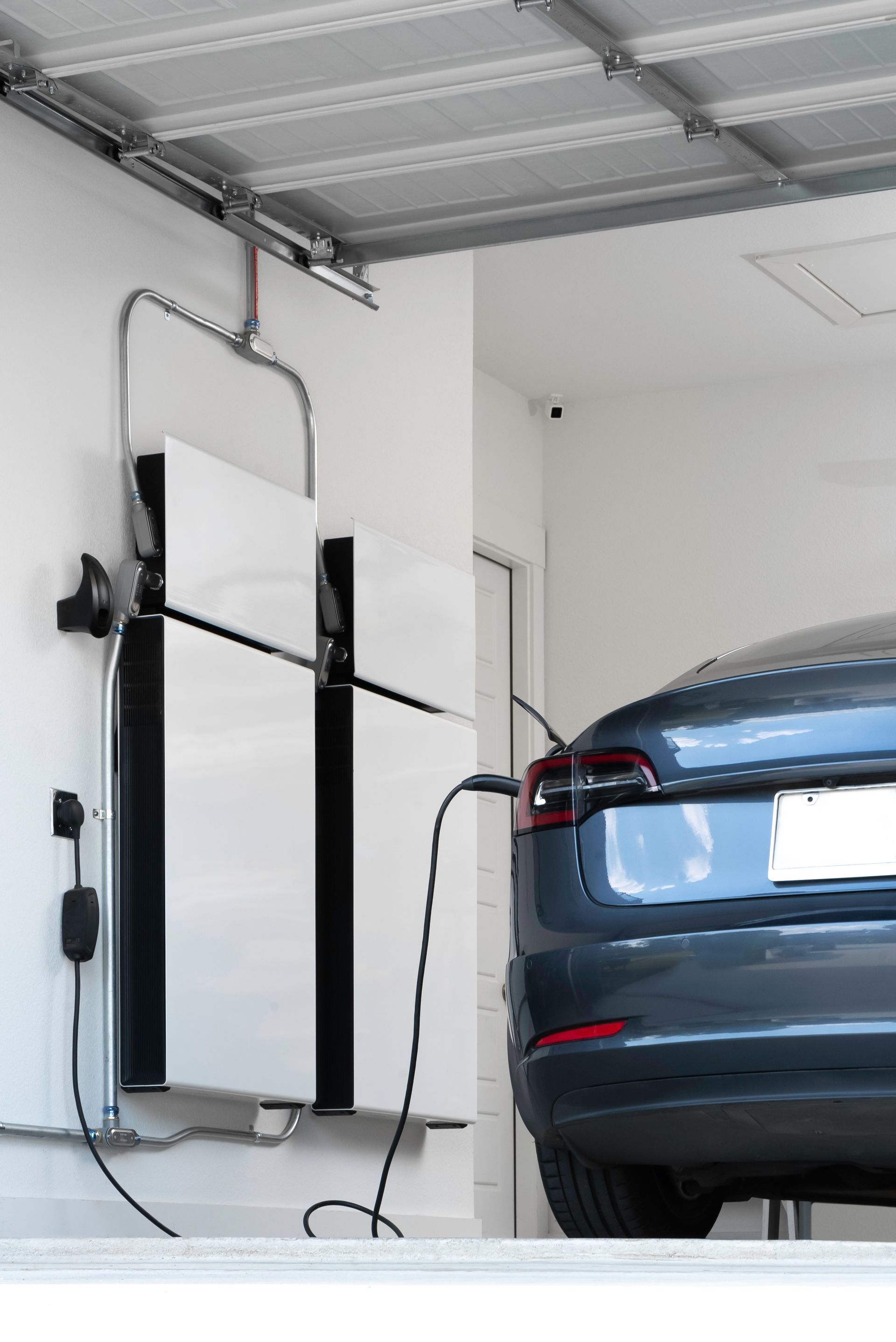 A car is being charged in a garage with a solar panel.