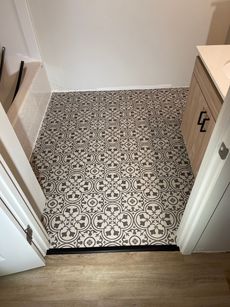 A bathroom with a tiled floor and a sink.