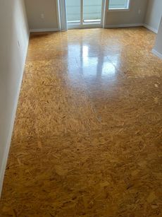 A living room with a cork floor and a sliding glass door.