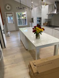 A kitchen with a large island and a vase of flowers on it.