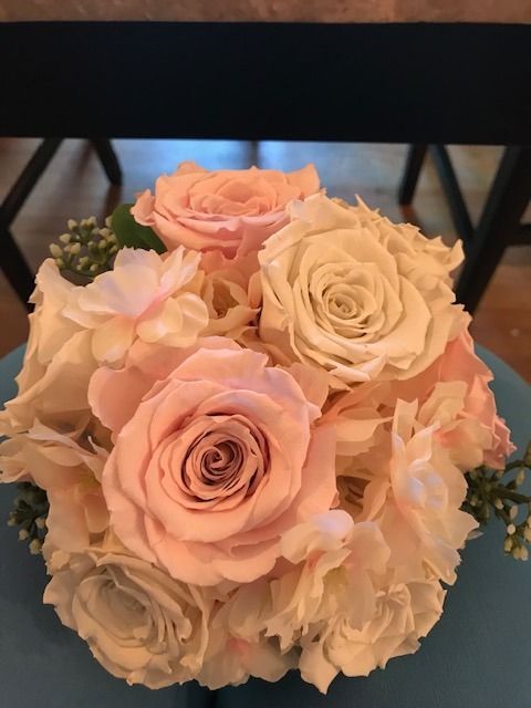Soft pink and ivory rose bouquet on a table, viewed from above
