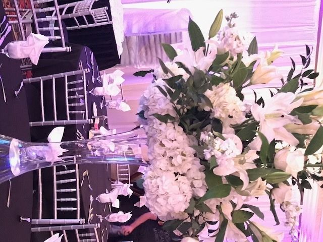 White floral centerpiece on a banquet table with glass decor in a softly lit event venue