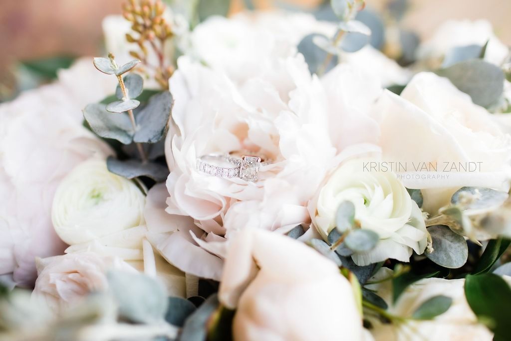 Soft pastel floral arrangement with white and blush flowers and green leaves
