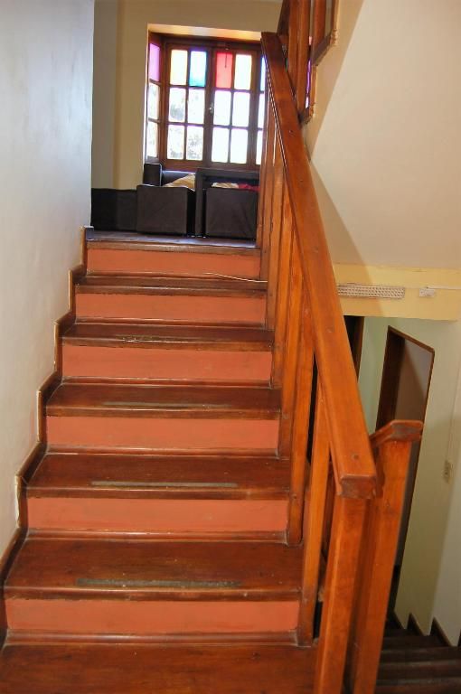 Escalera interior con pasamanos de madera que conduce a un rellano con ventana.
