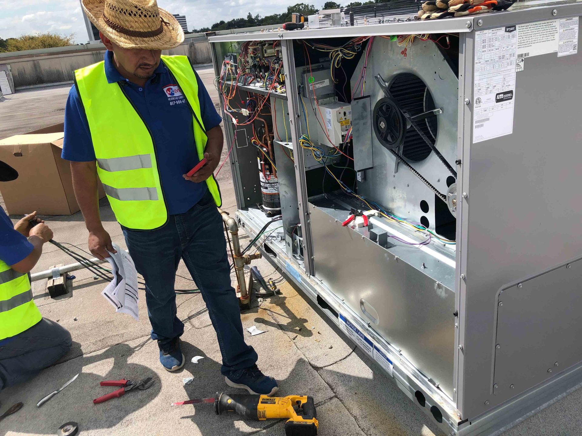 A man in a yellow vest is working on a machine - Fort Worth, TX - A/C Kives Heating & Air Conditioning