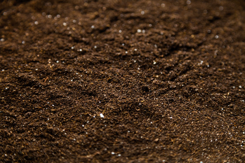 A close up of a pile of brown dirt with small stones in it.