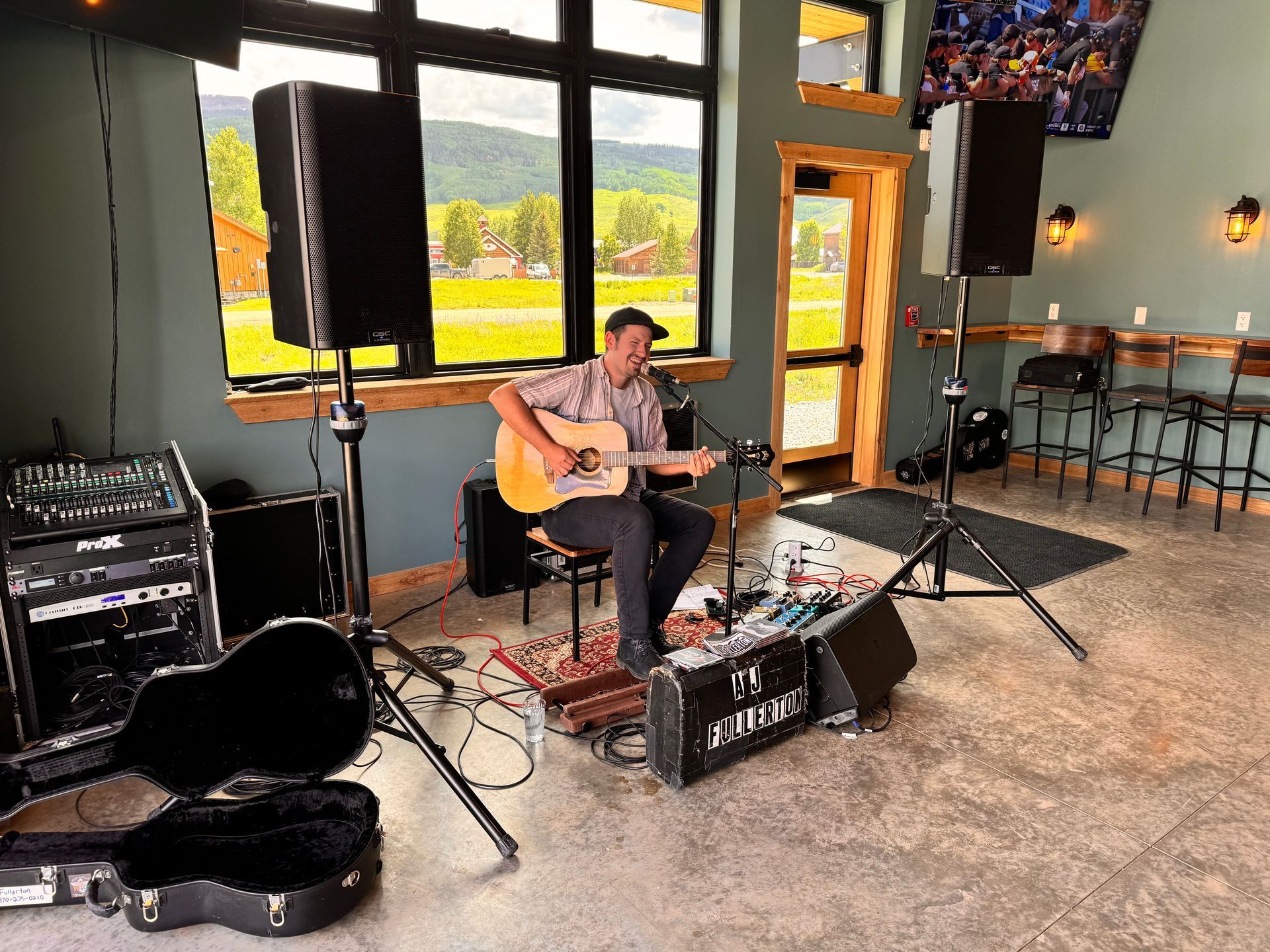 A man is playing an acoustic guitar in a room.