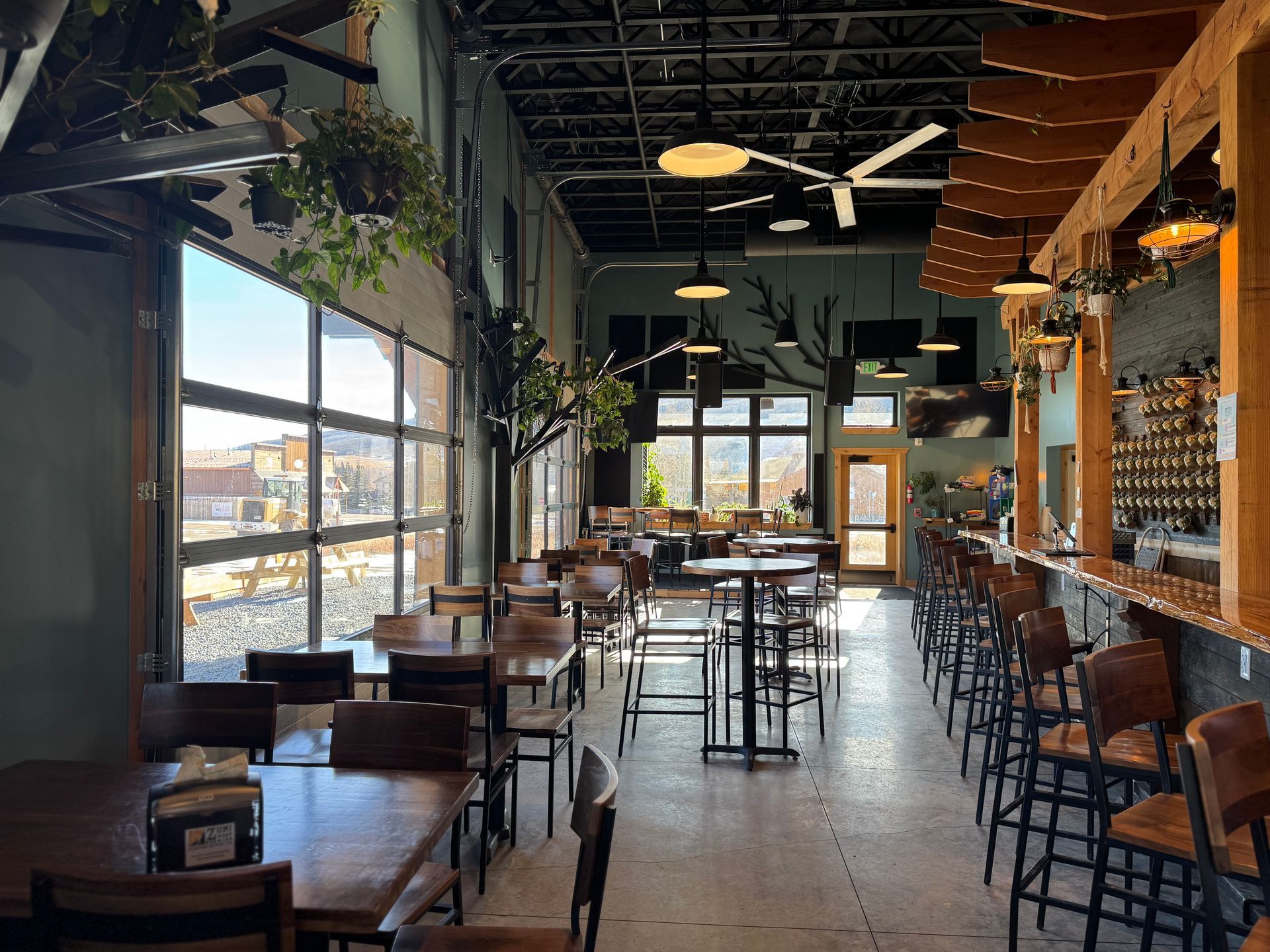 A restaurant with tables and chairs and a bar.