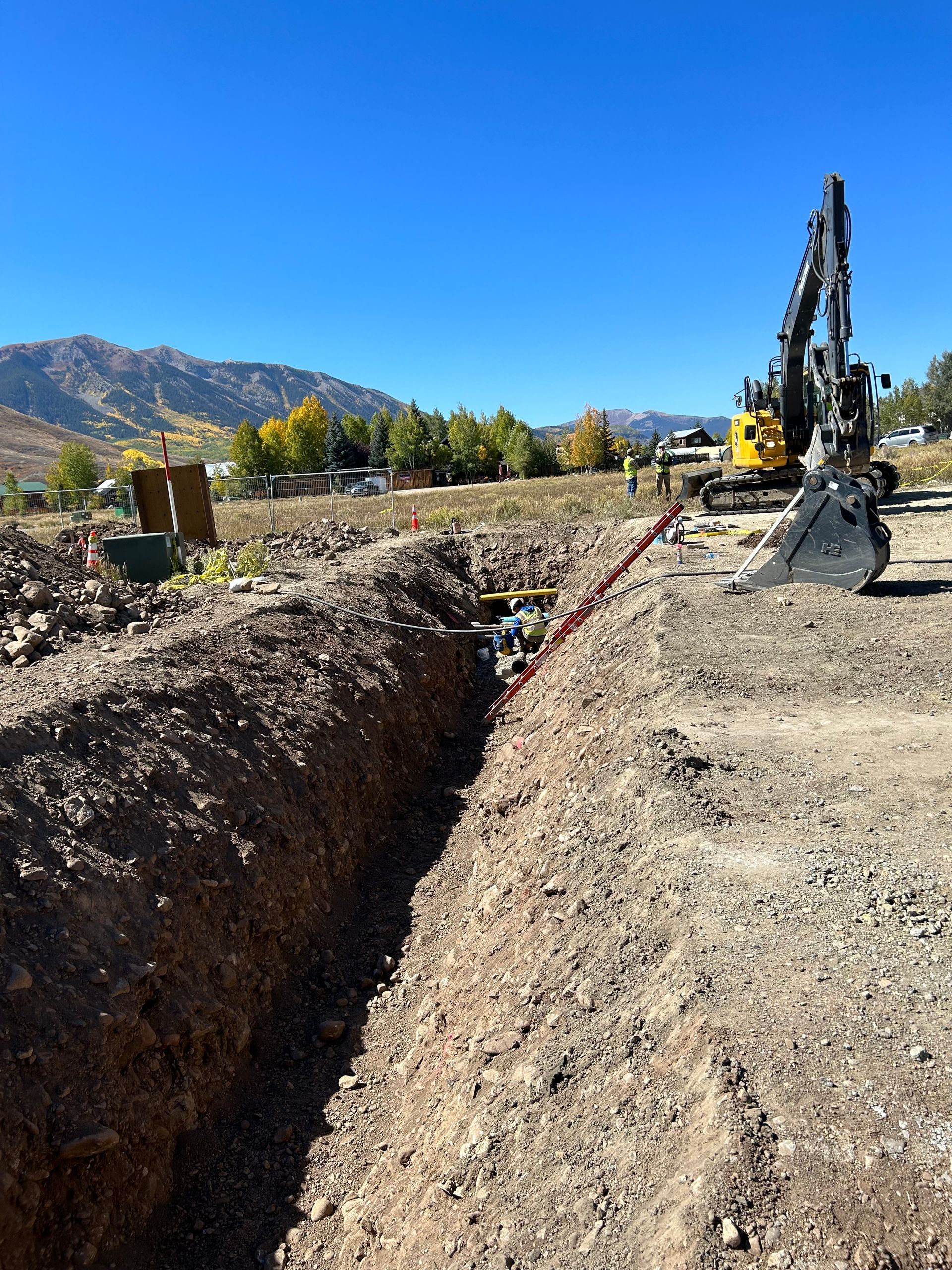 A bulldozer is digging a trench in the dirt.