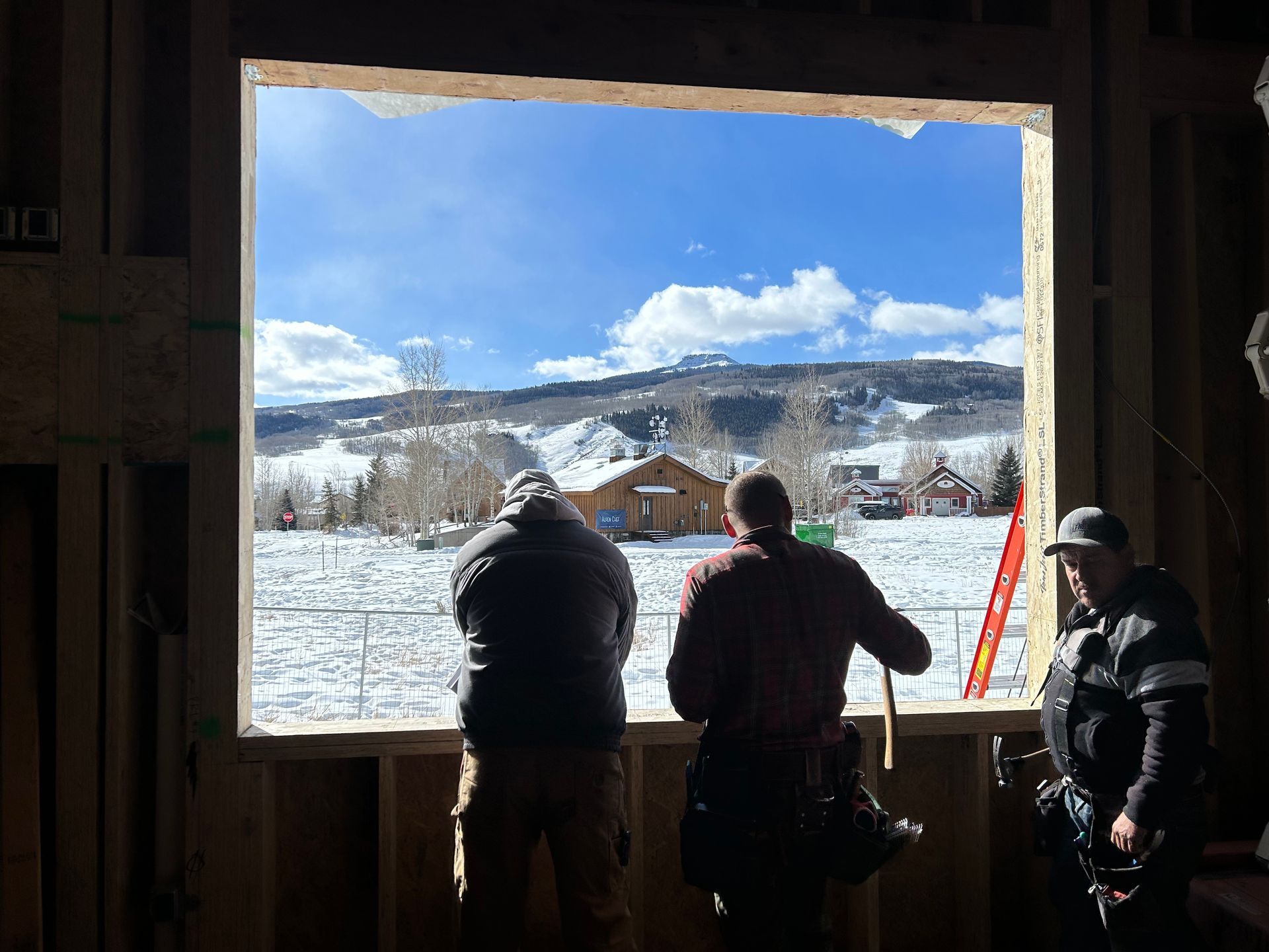 A group of men are looking out of a window at a snowy landscape.