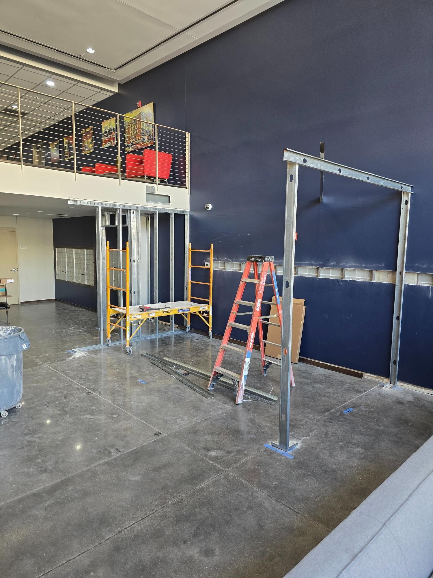 A room with a blue wall and a ladder in it.
