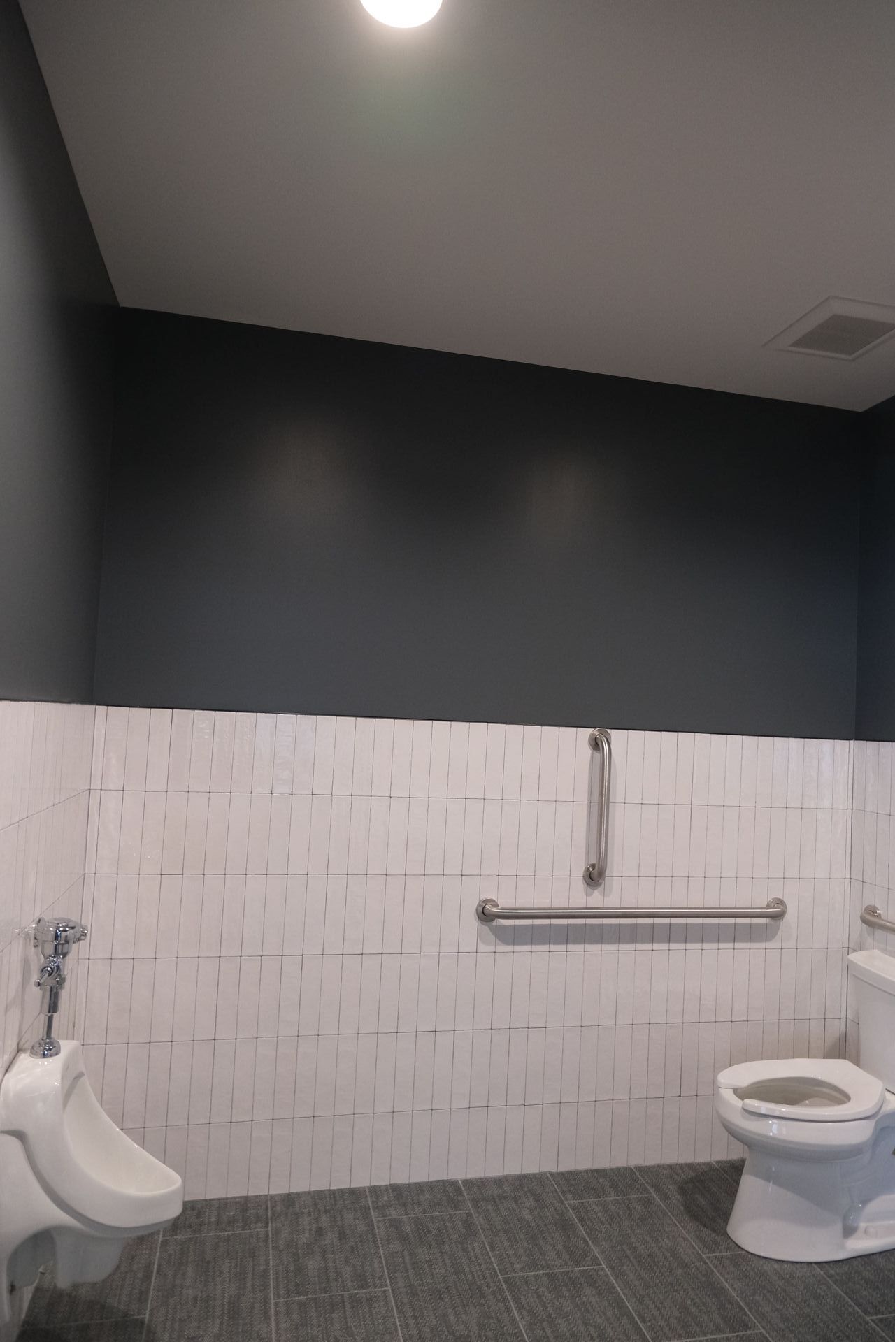 A bathroom with a urinal and a toilet