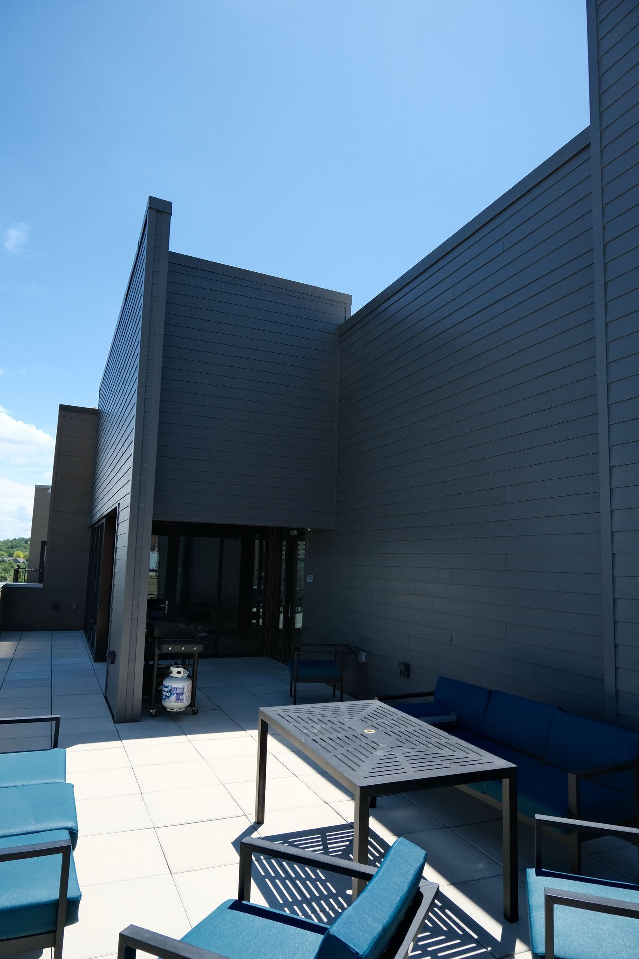 A patio with a table and chairs in front of a building.